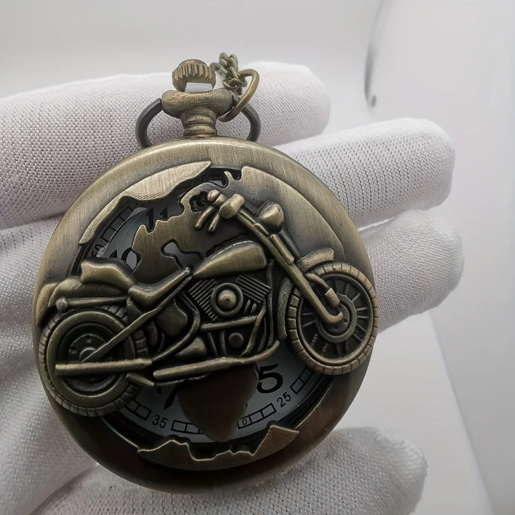 Close-up of bronze motorcycle pocket watch with intricate motorcycle design and vintage finish, held in a gloved hand.