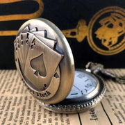 Partially open vintage bronze poker pocket watch highlighting the royal flush design and white quartz dial with Arabic numerals.