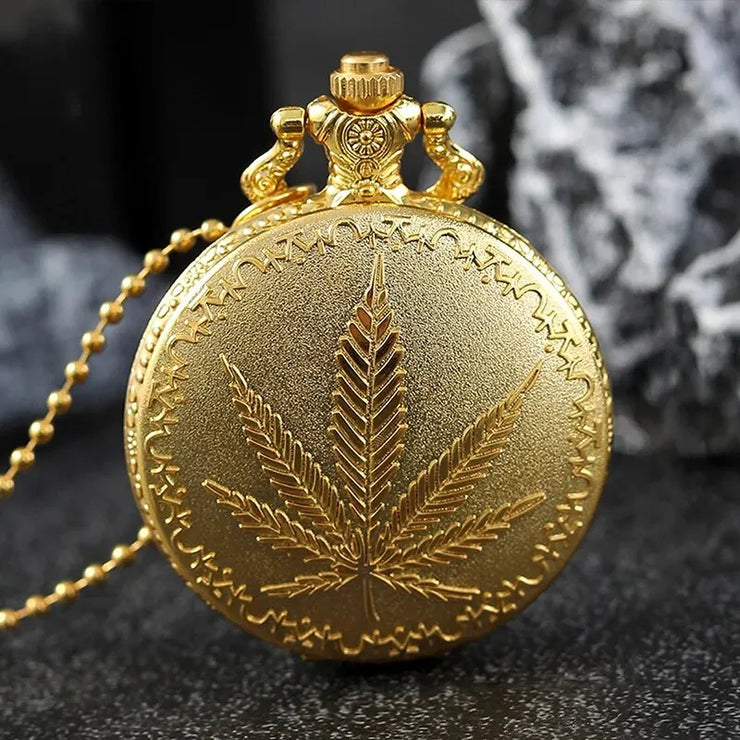 Gold vintage pocket watch with intricate design on a dark background.